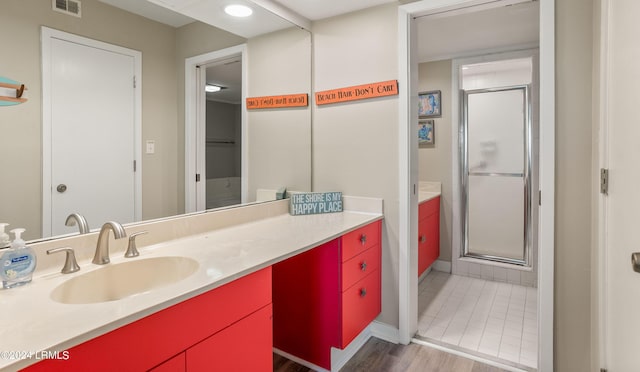 bathroom with vanity, hardwood / wood-style floors, and a shower with shower door