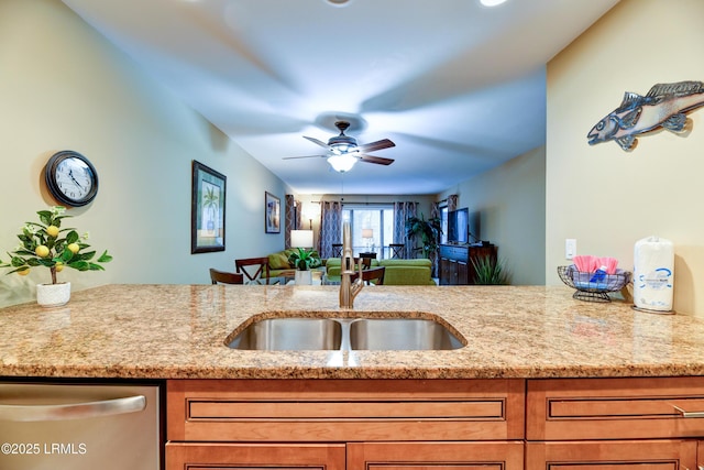 kitchen with light stone counters, ceiling fan, dishwasher, and sink