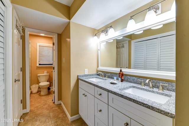 bathroom with tile patterned flooring, vanity, and toilet