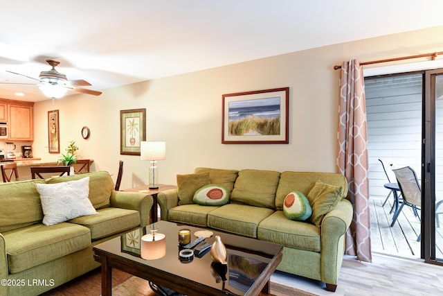 living room featuring ceiling fan and light wood-type flooring