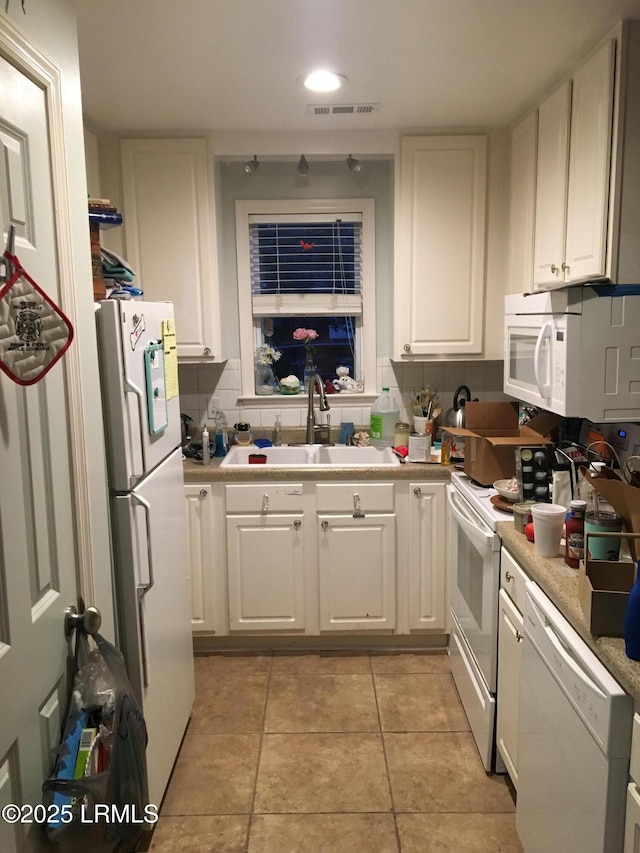 802 12th St, Port Royal, SC 29935 - kitchen featuring white appliances, a sink, white cabinetry, tasteful backsplash, and light countertops