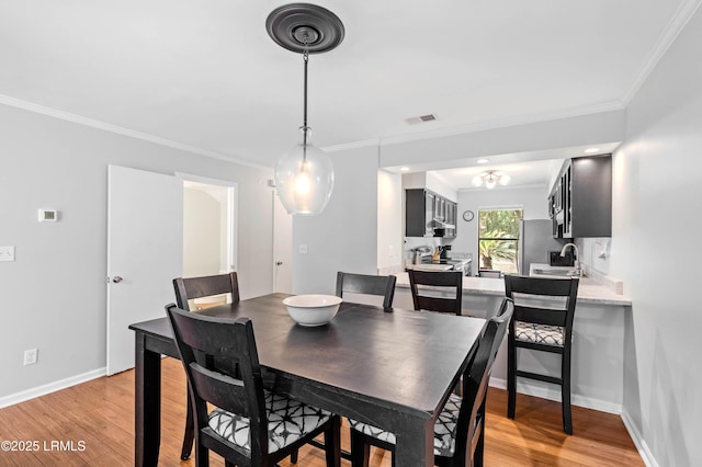 20 Battery Ln, Beaufort, SC 29902 - dining space with light wood-type flooring, crown molding, and baseboards