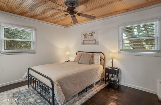 bedroom with dark wood-type flooring, ceiling fan, ornamental molding, and wooden ceiling