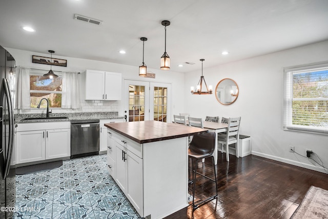 kitchen with sink, dishwasher, hanging light fixtures, a center island, and white cabinets