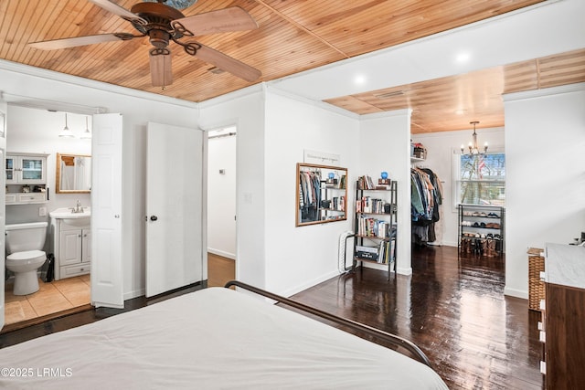 bedroom featuring wood ceiling, a walk in closet, sink, and a closet