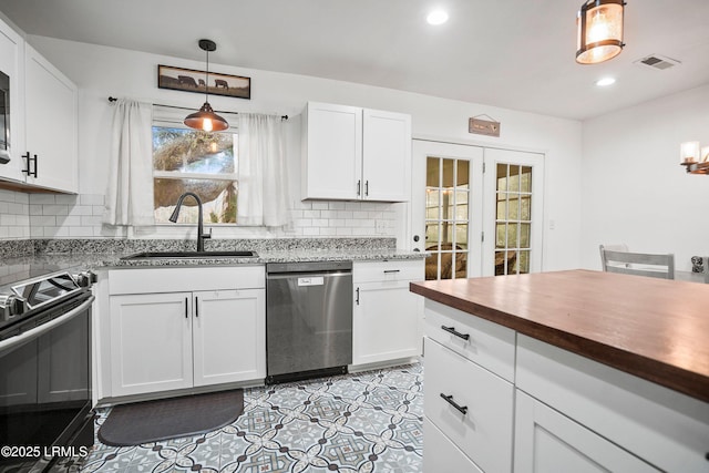 kitchen with electric stove, dishwasher, and white cabinets