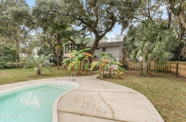 view of pool featuring a lawn