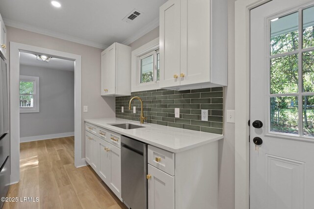 kitchen with decorative backsplash, dishwasher, a sink, light countertops, and white cabinets