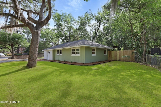 view of home's exterior featuring fence and a yard