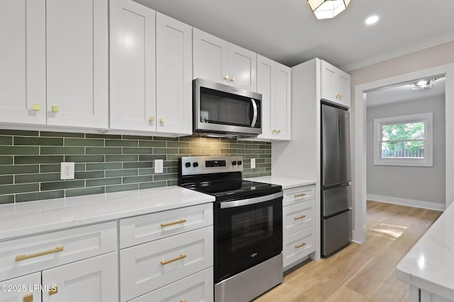 kitchen featuring stainless steel appliances, white cabinetry, light wood-type flooring, backsplash, and ornamental molding