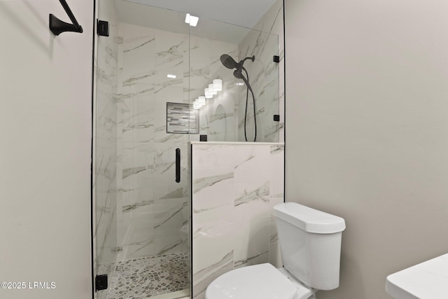 bathroom with toilet and a marble finish shower
