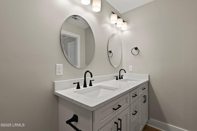 bathroom featuring double vanity, baseboards, visible vents, and a sink