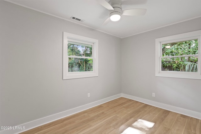 empty room with visible vents, ornamental molding, baseboards, and a healthy amount of sunlight