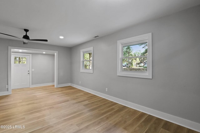 interior space featuring light wood-style floors, baseboards, ceiling fan, and visible vents