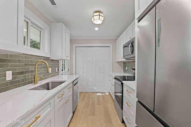 kitchen featuring stainless steel appliances, visible vents, white cabinetry, and a sink