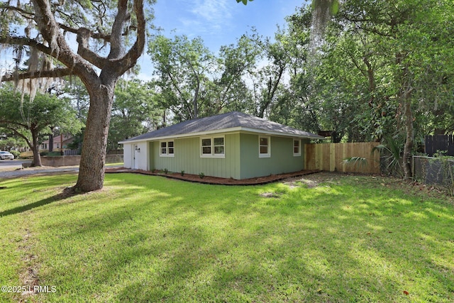 view of home's exterior with a lawn and fence