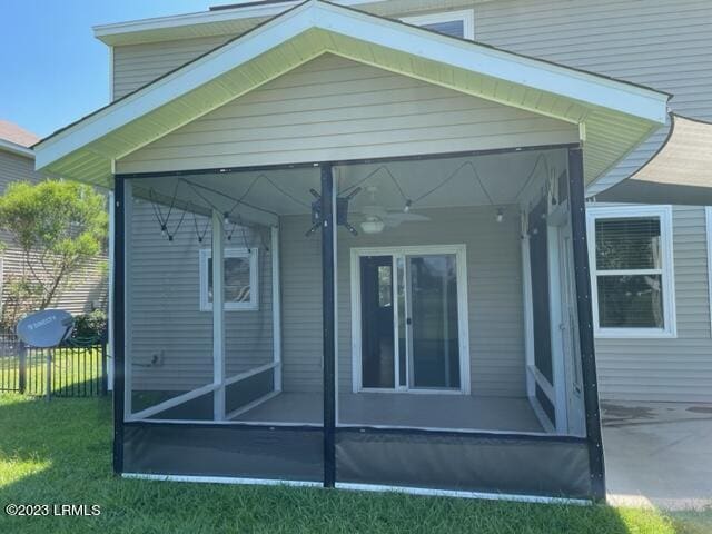 46 Pennyroyal Way, Beaufort, SC 29906 - view of side of home with a sunroom, a ceiling fan, fence, and a yard