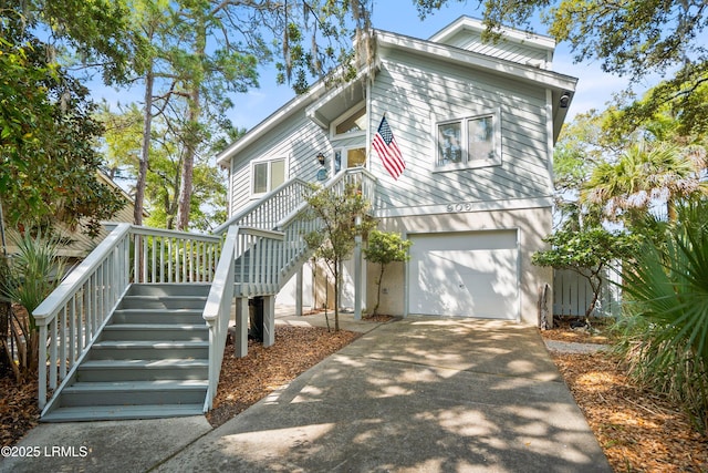view of front of house with an attached garage, driveway, and stairway
