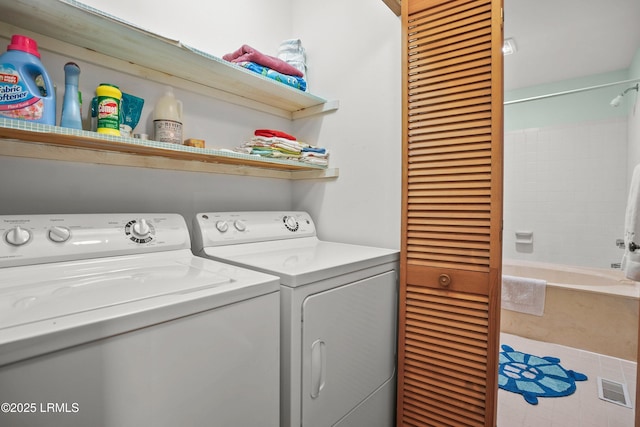 clothes washing area featuring laundry area and washer and clothes dryer