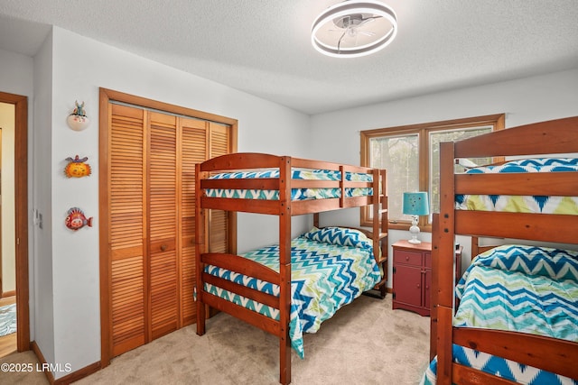 carpeted bedroom featuring a closet and a textured ceiling