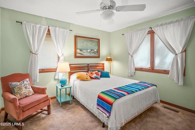 bedroom featuring visible vents, carpet flooring, baseboards, and a ceiling fan