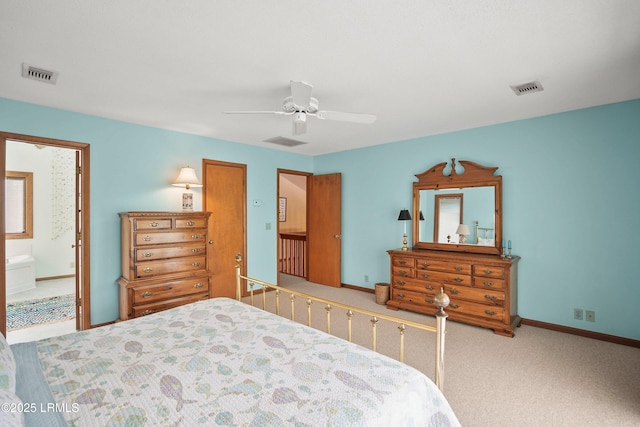 carpeted bedroom featuring ceiling fan, visible vents, baseboards, and ensuite bath