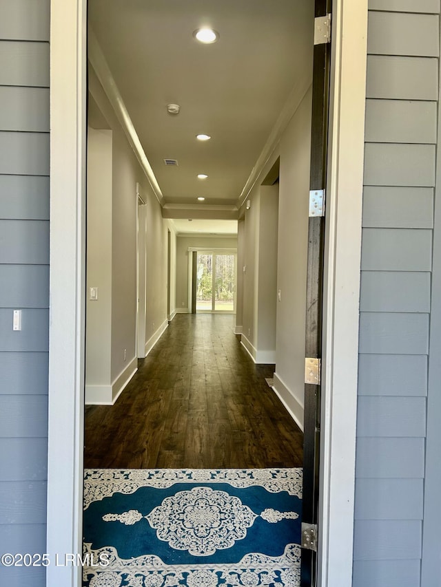 corridor with baseboards, visible vents, wood finished floors, crown molding, and recessed lighting