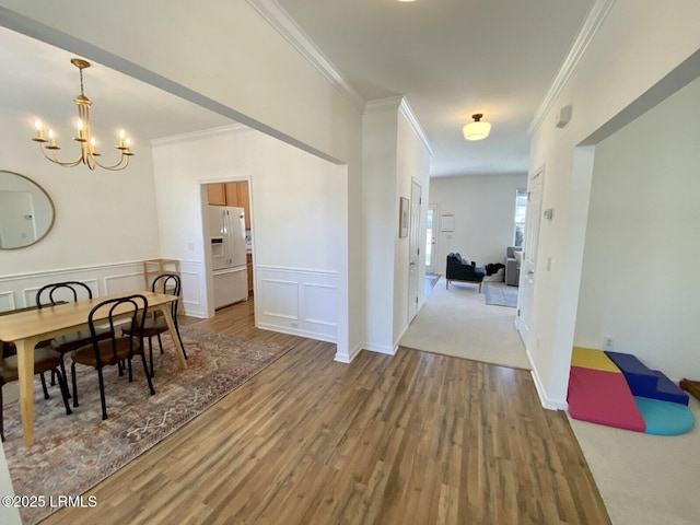 15 6th Ave, Bluffton, SC 29910 - dining room featuring crown molding, wood finished floors, a chandelier, wainscoting, and a decorative wall