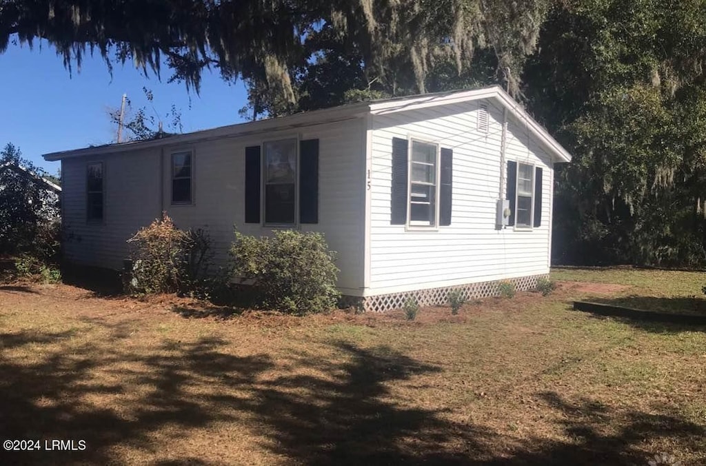 view of side of home with a lawn