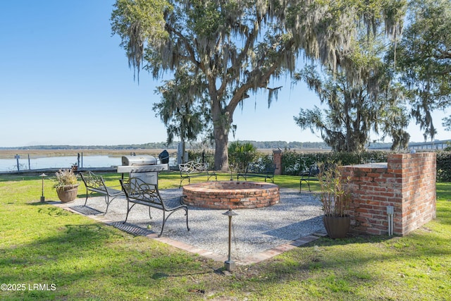 view of patio / terrace with a water view, area for grilling, and an outdoor fire pit