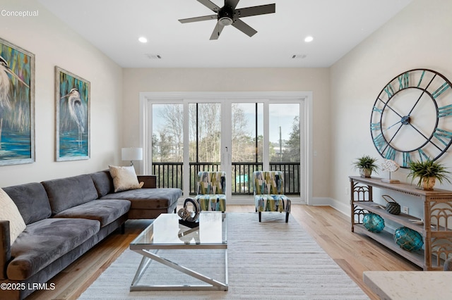 living room featuring ceiling fan and light hardwood / wood-style flooring