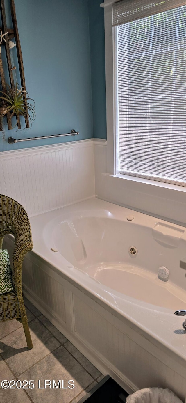 bathroom featuring wainscoting, a tub with jets, and tile patterned flooring