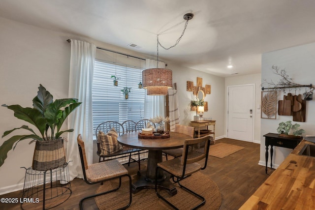 dining space featuring baseboards, visible vents, and dark wood-style flooring