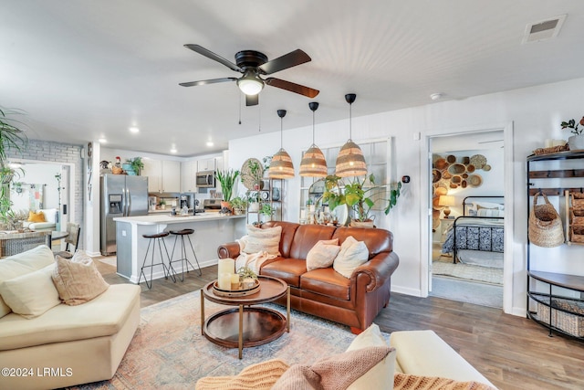 living room featuring a ceiling fan, recessed lighting, visible vents, and light wood-style floors