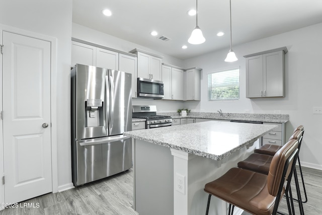 74 Keowee Ln, Beaufort, SC 29906 - kitchen featuring stainless steel appliances, gray cabinets, light wood-style flooring, a breakfast bar, and a kitchen island