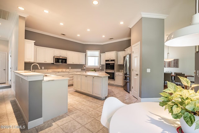 1348 Rowland Dr, Saint Helena Island, SC 29920 - kitchen with white cabinetry, appliances with stainless steel finishes, decorative light fixtures, and kitchen peninsula