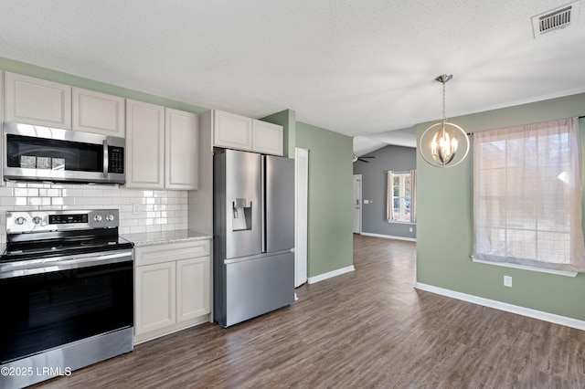 kitchen with dark wood-type flooring, tasteful backsplash, decorative light fixtures, appliances with stainless steel finishes, and white cabinets