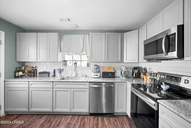 kitchen featuring stainless steel appliances, sink, and white cabinets