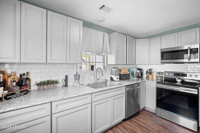 kitchen featuring tasteful backsplash, appliances with stainless steel finishes, sink, and white cabinets