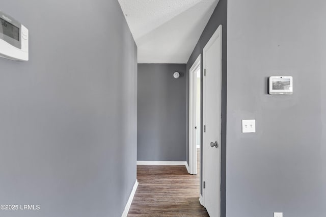 corridor featuring dark wood-type flooring and a textured ceiling