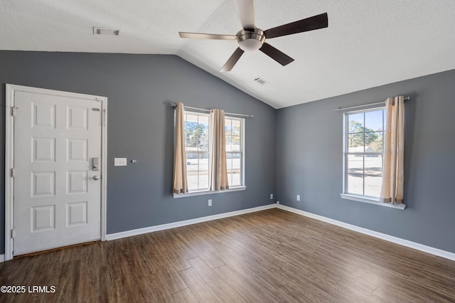 interior space with vaulted ceiling, dark hardwood / wood-style floors, ceiling fan, and a textured ceiling