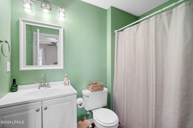 bathroom featuring vanity, a textured ceiling, and toilet