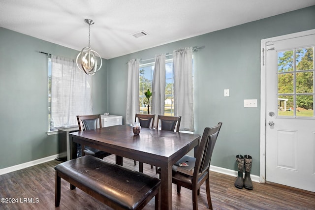 dining area featuring an inviting chandelier, dark wood-type flooring, and a wealth of natural light