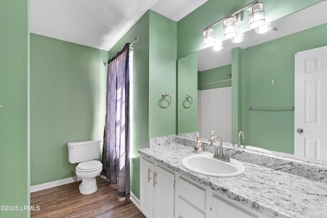 bathroom featuring wood-type flooring, toilet, and vanity