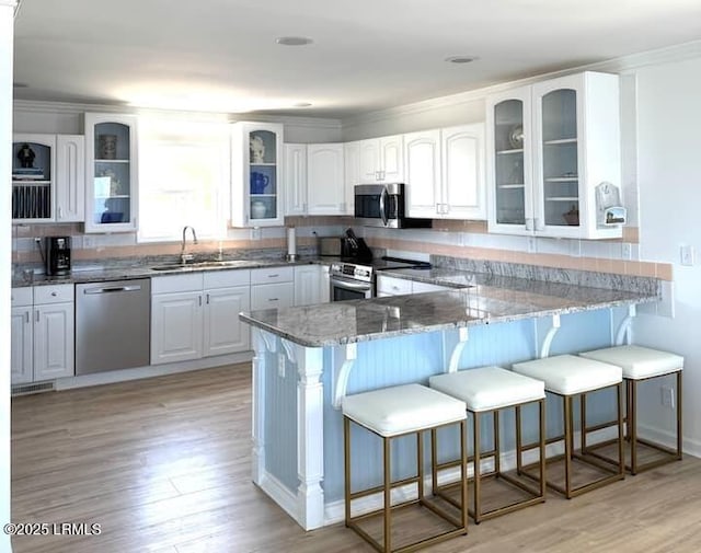 108 Harbor Dr N, Harbor Island, SC 29920 - kitchen with appliances with stainless steel finishes, a sink, a breakfast bar, a peninsula, and ornamental molding