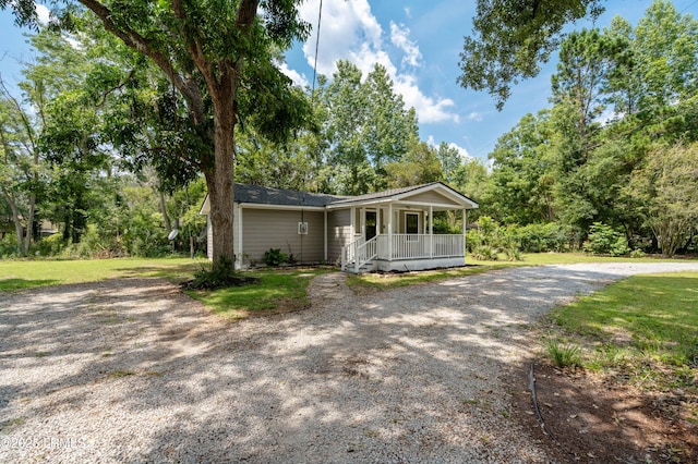 7058 Roseida Rd, Beaufort, SC 29906 - ranch-style house featuring a porch, gravel driveway, and a front lawn