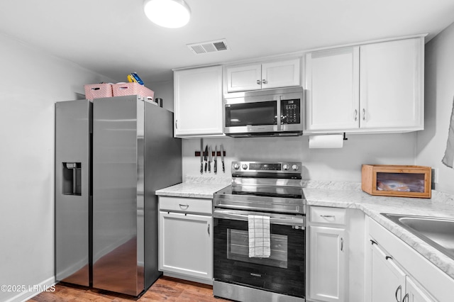 7058 Roseida Rd, Beaufort, SC 29906 - kitchen featuring stainless steel appliances, white cabinets, and light wood-type flooring