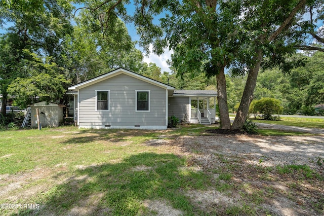 7058 Roseida Rd, Beaufort, SC 29906 - view of front of home with crawl space, a storage unit, a front yard, and covered porch