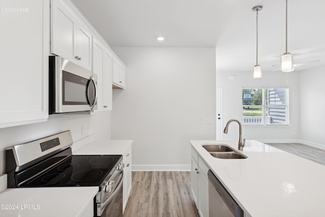 kitchen with sink, white cabinetry, light hardwood / wood-style flooring, pendant lighting, and stainless steel appliances