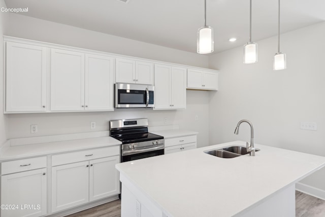 kitchen featuring white cabinetry, stainless steel appliances, sink, and an island with sink